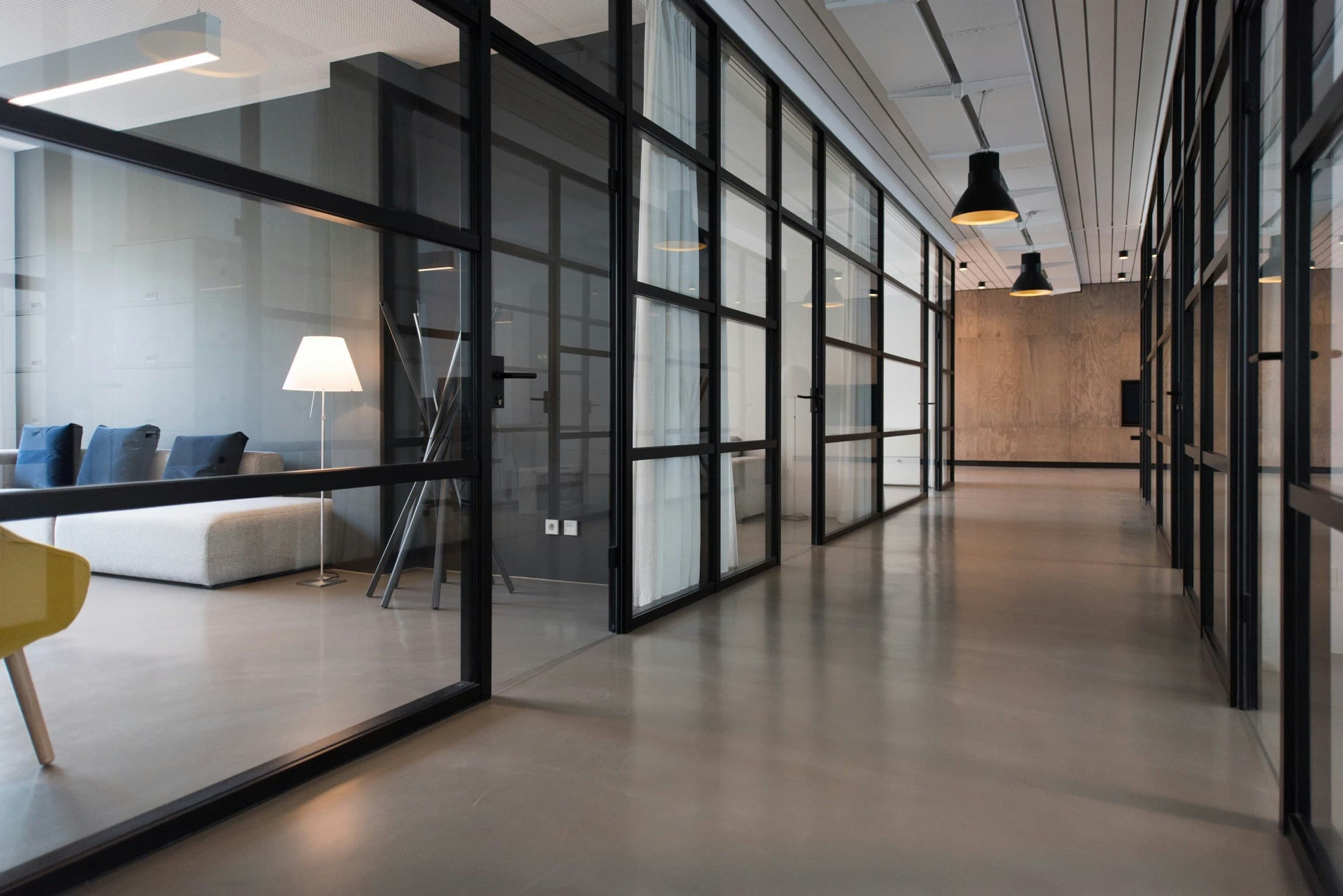 Bright modern office corridor with glass-panelled doors